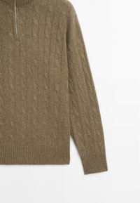 Maglione marrone a maglia a treccia con colletto alto e chiusura a mezza zip. Presenta polsini e orlo a costine; morbida texture e design classico.