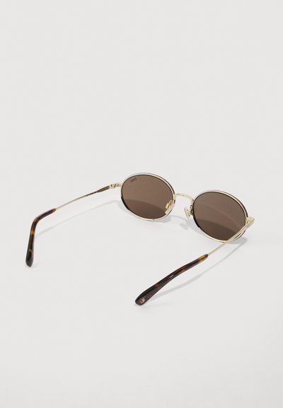 Ochelari de soare rotunzi cu lentile maronii, ramă din metal auriu și brațe cu model piele de țestoasă. Design ușor cu branding subtil pe lentile.