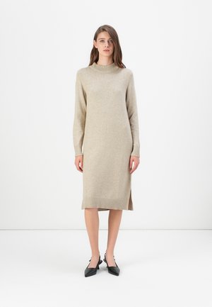 Lichtbeige trui-jurk met een geribde col, lange mouwen en zijsplitten. Gemaakt van zacht materiaal, heeft het een rechte, elegante snit.