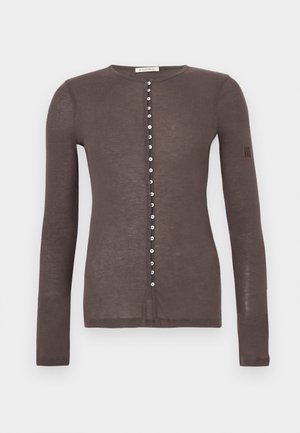 Cardigan maro cu mâneci lungi, cu nasturi mici albi pe partea din față și cu decolteu rotund.