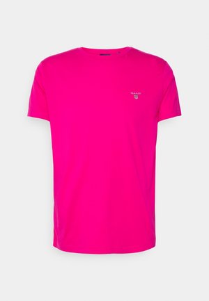 Bright pink short-sleeve crew neck T-shirt with small white GANT logo and shield emblem on the left chest.
