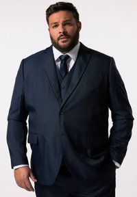 Granatowy, trzyczęściowy garnitur o fakturowanym wykończeniu, jedno-guzikowa marynarka, klapy z wcięciem i kieszenie boczne; połączony z białą koszulą i krawatem.