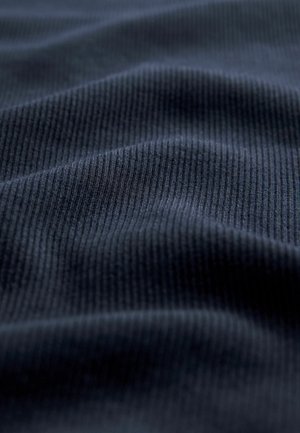 Marineblauer gerippter Stoff mit einer weichen Textur, der subtile Wellen und Falten zeigt und die Elastizität und Struktur des Materials betont.