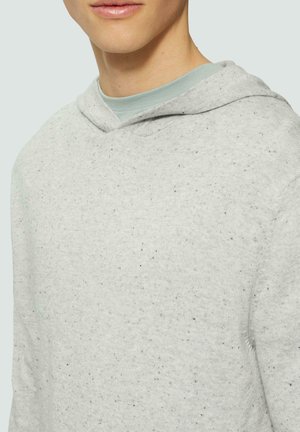 Sweatshirt à capuche gris clair avec une finition texturée, présentant des nuances sombres, une poche kangourou et un col doux et décontracté.