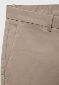 Beige Hosen aus einem glatten, texturierten Stoff. Verfügen über einen geraden Bund, Fronttaschen und subtile Nähte.