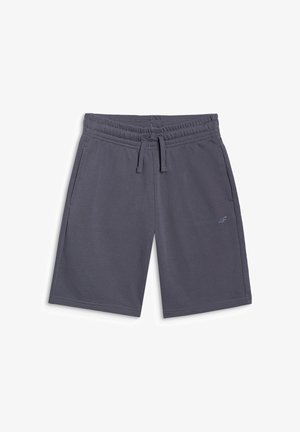 Garçon portant une casquette grise, un t-shirt manches longues vert néon, un short gris foncé, des chaussettes blanches et des baskets grises, debout, faisant face à l'avant.