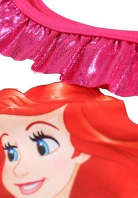 Haut de bain rose avec un col froncé brillant et un design de personnage de dessin animé avec des cheveux roux proéminents et des yeux bleus.