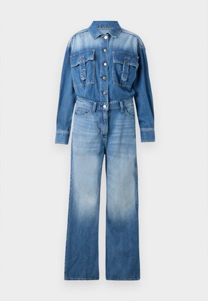 Macacão de ganga em azul claro, com frente de botões, dois bolsos no peito, mangas longas, detalhe de cinto e silhueta de pernas largas com desvanecimento.