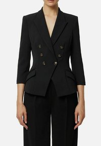 Blazer nero doppiopetto con maniche a tre quarti, bottoni tono oro, spalle strutturate e tasche laterali. Tessuto dalla texture liscia.
