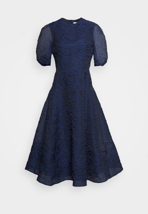 Vestido azul-marinho com mangas curtas em balão e um padrão floral texturizado, corpete ajustado e saia evasé. Fecho de correr na parte de trás.