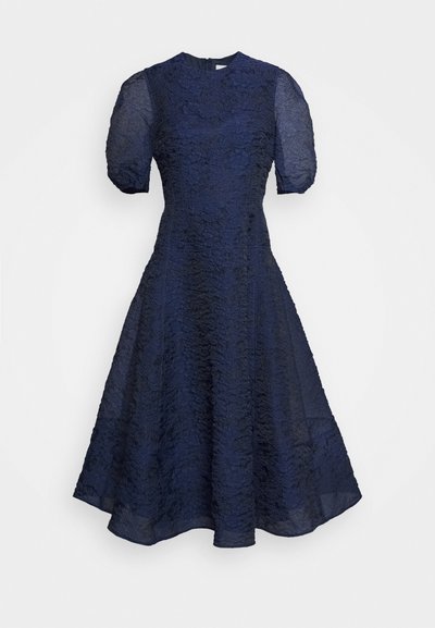 Vestido azul-marinho com mangas curtas em balão e um padrão floral texturizado, corpete ajustado e saia evasé. Fecho de correr na parte de trás.