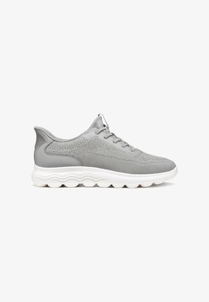 Chaussures de sport grises avec une tige en maille et des accents synthétiques, présentant un bout arrondi et une semelle blanche texturée avec des détails en vagues.