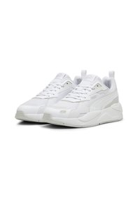 Paire de baskets de sport blanches Puma avec laçage, tige en mesh et synthétique, et semelles rembourrées sur fond blanc.