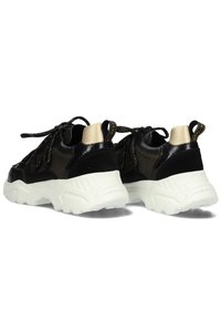 Zwarte sneakers van mesh en lakleer, met een chunky witte zool en gouden accenten op de hiel en het vetersysteem.