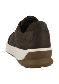Brązowy skórzany sneaker z wyściełanym kołnierzem, białą podeszwą pośrednią i brązową gumową podeszwą, pokazany z tylnego kąta na białym tle.