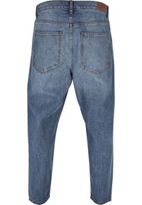 Denim jeans in light blue with a relaxed fit. Features include two back pockets, a straight leg, and a waistband with a leather patch.