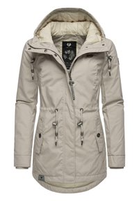 Beige gewatteerde jas met een ritssluiting aan de voorkant, een trekkoord in de taille en een capuchon. Voorzien van twee zijzakken en contrasterende voering. Accenten in zilver hardware.