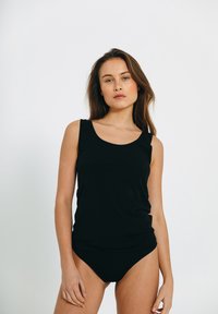 Sort ærmeløs top og matchende trusser, begge lavet af glat stof. Toppen har en rund halsudskæring og en afslappet pasform.