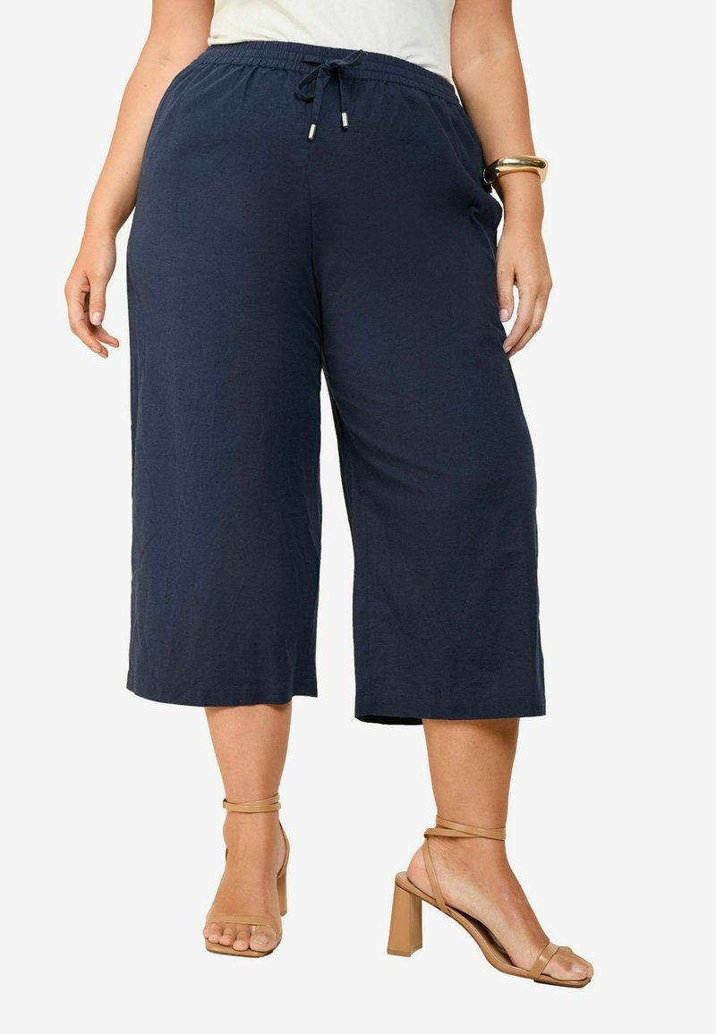 Marineblaue, kurz geschnittene Hosen aus leichtem Stoff mit einem elastischen Bund und Kordelzug. Mit Seitentaschen und einer lockeren Passform.