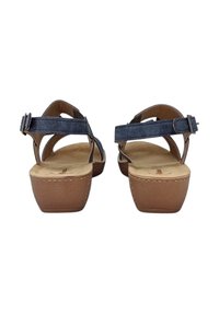Sandali blu con cinturini e tacco a blocco in tessuto color tan. Fibbia regolabile alla caviglia e soletta imbottita visibili. Parte superiore in pelle liscia.