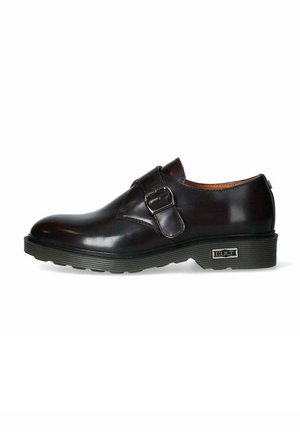 Scarpa in pelle marrone scuro con una fascetta a fibbia, punta rotonda, suola in gomma texturizzata e finitura lucida. Include il marchio sul lato.