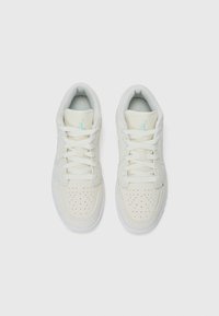 Valged sneakers perforatsiooniga varbavarre, lame pael ja helesinine aktsent keeles ja logos. Sile materjal, madala tipuga disain.