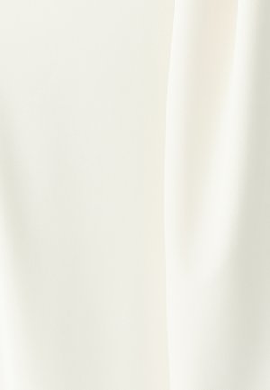 Valge kangas, millel on sile, matt tekstuur õrna diagonaalse mustriga, langeb pehmelt volditud varje ja varjudega.