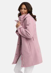 Pink, fleece-lined coat with a high collar, snap buttons, and side pockets. Features a decorative detail on the zipper pull.