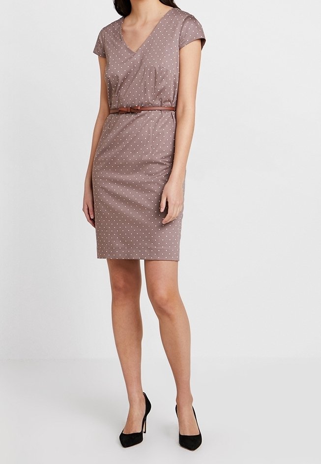 Robe marron à pois avec manches courtes, encolure en V, coupe ajustée et ceinture marron à la taille. Portée avec des chaussures à talons hauts noires.