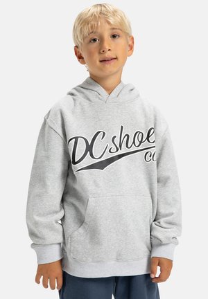 Sweatshirt gris clair avec capuche, présentant un grand logo noir sur le devant, une poche kangourou et des poignets côtelés. Tissu en mélange de coton doux.
