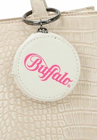 Beige strukturiertes Kunstleder-Handtasche mit Krokodilmuster und einem runden, weißen Etikett mit pinkem "Buffalo"-Logo und Metallverschluss.