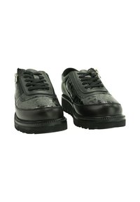 Par de zapatos negros de tacón bajo con paneles frontales texturizados, cierre de cordones y cremalleras laterales en suelas gruesas de goma.