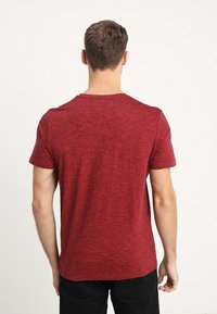 Rode heathered crew neck t-shirt gemaakt van een zachte katoenmix, korte mouwen, slimfit ontwerp. Glenige textuur zonder zichtbare patronen of accenten.