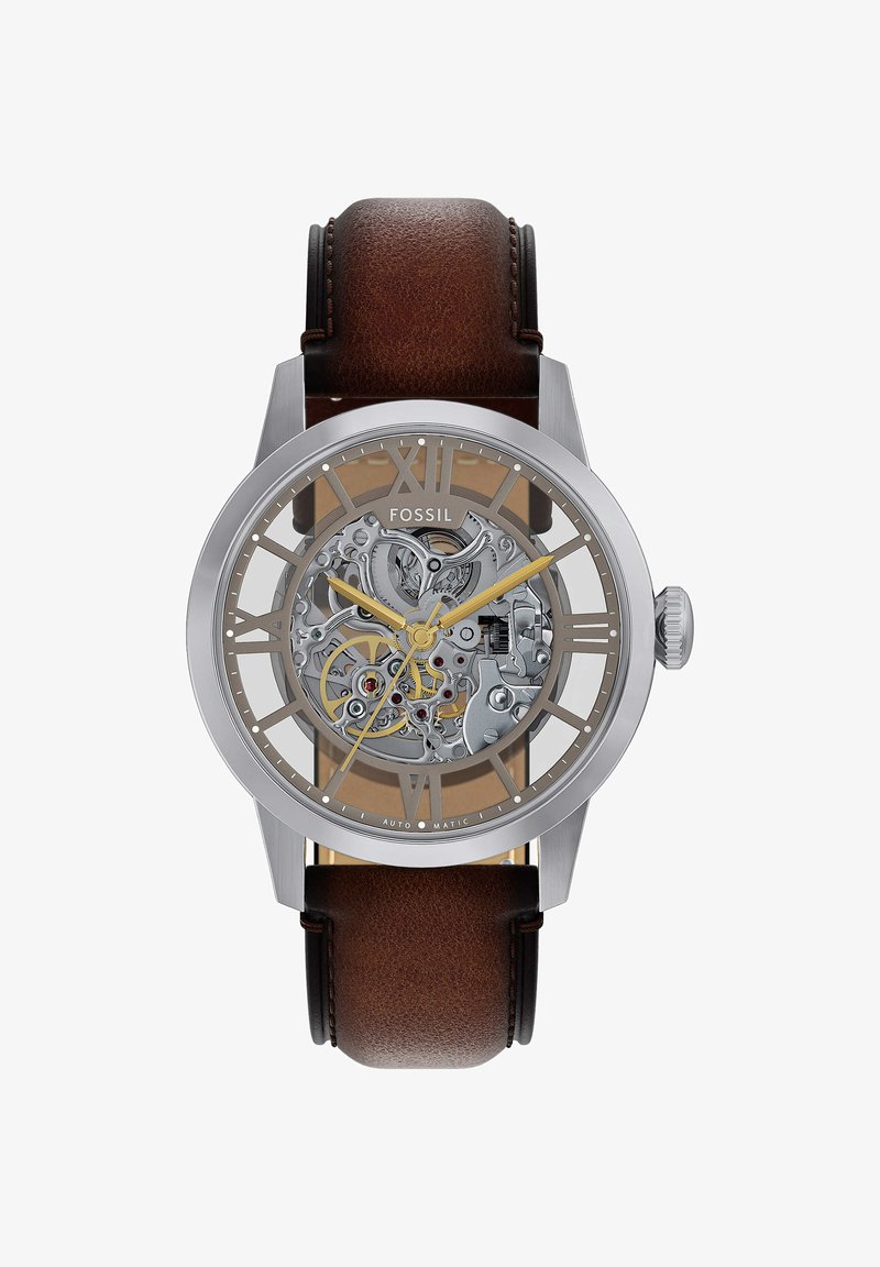 Heren Fossil automatisch horloge met zilverkleurige kast, skelet wijzerplaat die mechanische tandwielen toont, gouden wijzers, Romeinse cijfers en een bruine leren band.