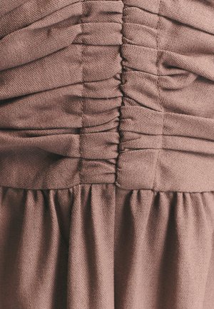 Hnědá texturovaná látka s řasením v pase, přecházející do vzdušné sukně. Hladký povrch s jemným leskem a měkkými záhyby.
