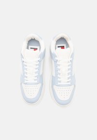 Vita och ljusblå sneakers med perforerad tåbox, snörning, vadderad krage och varumärkeslogotyp på tungan. Gummisulor.