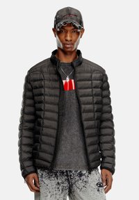 Black padded jacket with a stand-up collar, zip closure, and gray sweater underneath. Accessories include a distressed gray cap and necklace.