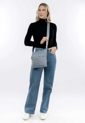 Szara torba na ramię o gładkiej teksturze, z długim paskiem, dwoma przednimi kieszeniami na zamek błyskawiczny oraz małym logiem marki na dole.