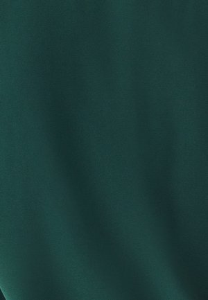 Tume roheline kangas sileda, mati tekstuuriga. Materjalil on pehme, ühtlane pind ja minimaalne sära, mis peegeldab valgust vaevu.