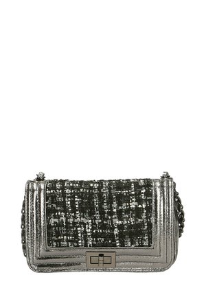 Metalen zilveren handtas met een getextureerde geweven stof aan de voorkant. Beschikt over een rechthoekige vorm, kettingriem en een sluiting met een klapmechanisme.