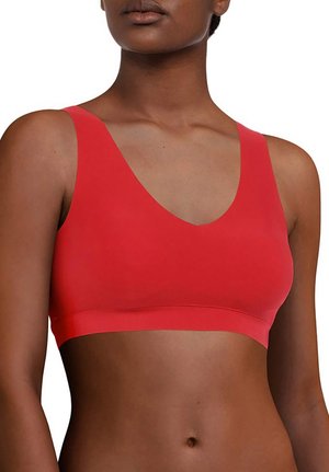 Red wireless bralette with a smooth texture, V-neck design, wide shoulder straps, and a fitted band, providing seamless support.
