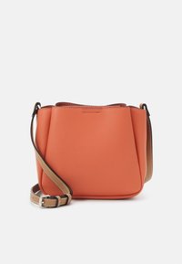 Pomarańczowa torba crossbody z teksturowanej skóry, z regulowanym brązowym paskiem i srebrną klamrą, na białym tle.