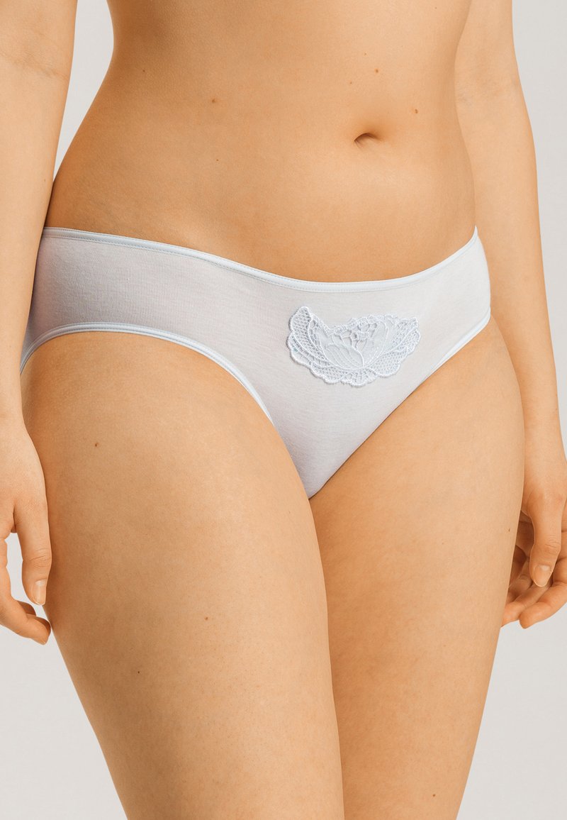 Vaaleansiniset puuvillapikkarit, joissa on pitsikukkakuvio etuosassa. Suunnittelu on saumaton ja siinä on pehmeä, sileä rakenne.