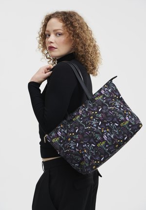 Black floral tote bag with colorful plant patterns, fabric material, zip closure, and dual black handles for easy carrying.