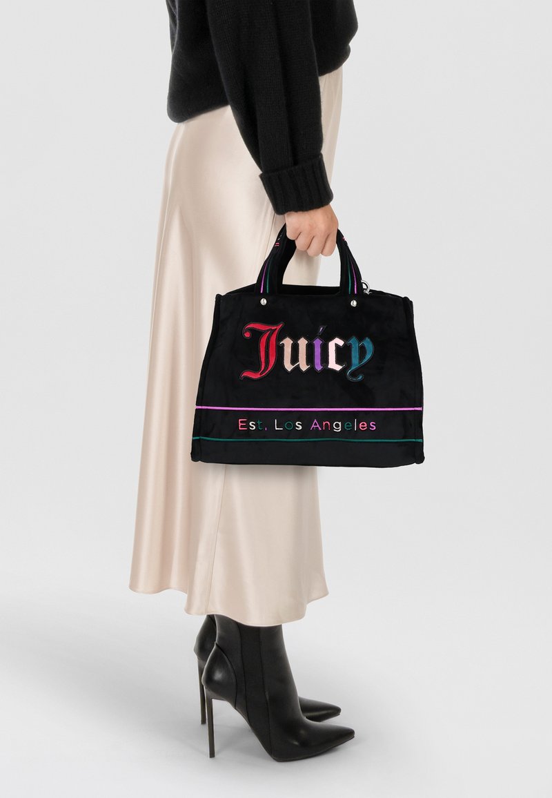 Borsa a mano in tessuto nero con logo "Juicy" colorato, hardware argentato e manici a righe in contrasto. Forma rettangolare, design compatto, texture liscia.