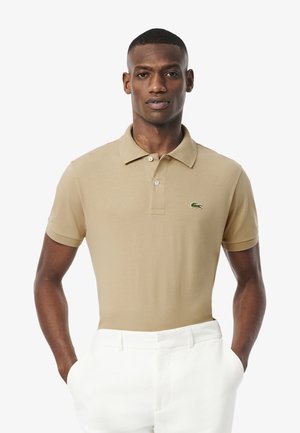 Beige polo shirt van katoenmix, met korte mouwen, een klassieke kraag en drie knopen. Heeft een klein groen logo op de borst.