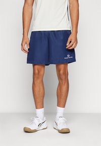 Navy athletic shorts with an elastic waistband, made of lightweight fabric. Features white logo detail on the lower hem.