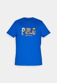 Blå bomulls t-shirt med en färgglad broderad "POLO"-logotyp med olika mönster och texten "Ralph Lauren" nedanför. Rund halsringning, korta ärmar.