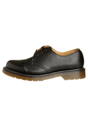 Chaussure noire en cuir à lacets avec un embout arrondi, surface lisse, coutures discrètes et une semelle épaisse en caoutchouc brun.