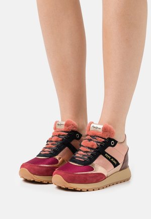 Zapatillas deportivas que combinan varios materiales, con detalles en rosa suave, burdeos y negro, lengüetas forradas de piel y superficies texturizadas.